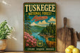 A vintage-style metal sign for Tuskegee National Forest in Alabama, featuring a scenic landscape with a deer, surrounded by pine trees and a river.