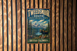 A vintage metal sign for Tweedsmur, South, and British Columbia, featuring a moose in a forest setting with mountains in the background.