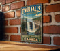 A vintage-style sign for Twin Falls, a waterfall located in Northwest Territories, Canada.