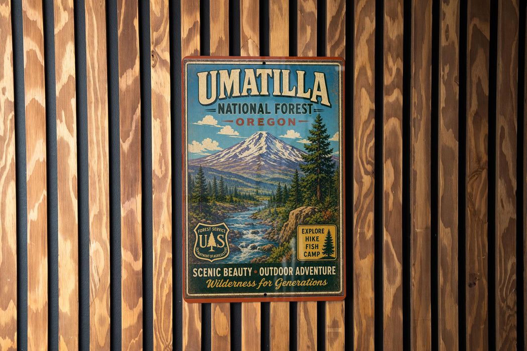 A vintage-style metal sign for the Umatilla National Forest in Oregon, featuring a scenic mountain landscape and promoting outdoor adventure and wilderness experiences.
