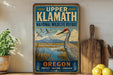 A vintage-style sign for Upper Klath National Wildlife Refuge in Oregon, featuring a bird and a scenic landscape.