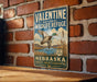 A vintage-style metal sign for Valentine National Wildlife Refuge in Nebraska, featuring a duck in flight and a scenic landscape.