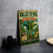 a vintage-style metal sign with a tropical landscape and text, placed on a gray countertop next to some black camera lenses.