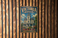 A vintage-style metal sign for "Victoria mansion" is displayed on a wooden wall, featuring an illustration of a Victorian-style mansion surrounded by trees and flowers.