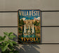 A vintage-style metal sign with the text "Villa d'Este" and "Tivoli Italy" displayed on it, featuring an illustration of a fountain and buildings.
