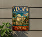 A vintage metal sign for the Vizzaya Museum and Gardens in Florida, featuring an illustration of a building and palm trees.