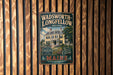 A vintage metal sign for the Wadsworth-Longfellow House in Maine, featuring an illustration of the house and the text "Wadsworth-Longfellow House" and "Stop into America's Literature Heritage".