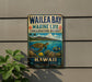 A vintage metal sign for Wailea Bay, Hawaii, featuring a turtle and tropical plants, mounted on a wall.