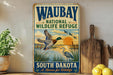 A vintage-style metal sign for the Waubay National Wildlife Refuge in South Dakota, featuring illustrations of ducks and other wildlife.