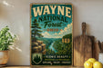 A vintage-style metal sign for Wayne National Forest in Ohio, featuring a scenic landscape with a river and mountains.