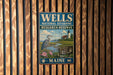 A vintage metal sign for the Wells National Estuarine Research Reserve in Maine, featuring a seagull and a lighthouse.