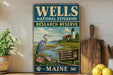 A vintage-style sign for Wells National Estuarine Research Reserve in Maine, featuring a seagull, a lighthouse, and a coastal landscape.