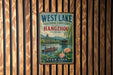 A vintage-style sign for West Lake, a cultural landscape in Hangzhou, China, featuring a scenic image of boats on a lake surrounded by traditional Chinese architecture and vegetation.