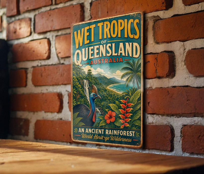 A vintage-style metal sign with the text "WET TROPICS OF QUEENSLAND AUSTRALIA" and an illustration of a tropical landscape, including a waterfall, palm trees, and colorful flowers.