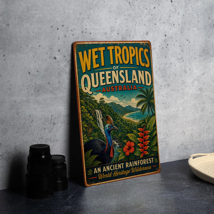 A vintage-style sign advertising the Wet Tropics of Queensland, Australia, featuring a colorful illustration of a bird, palm trees, and other tropical elements.