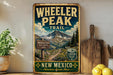 A vintage-style metal sign for Wheeler Peak Trail in New Mexico, featuring a mountain landscape and trail information.