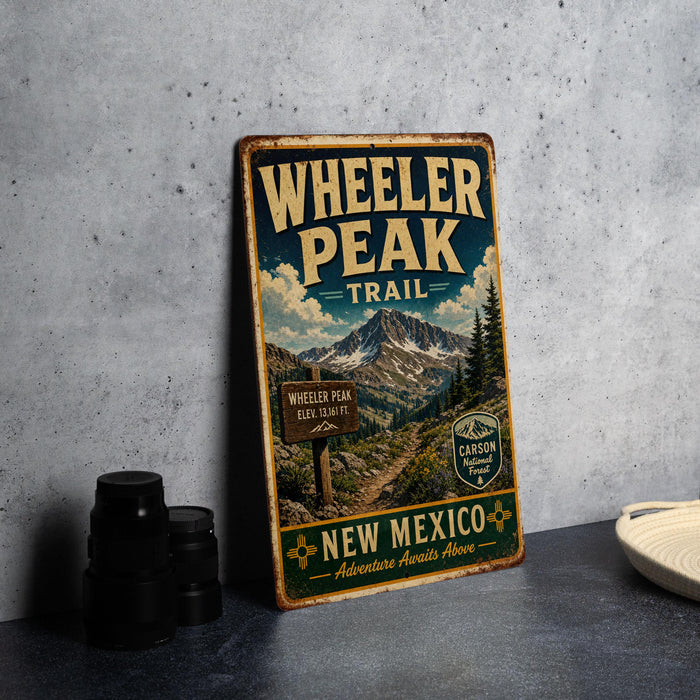 A vintage metal sign for Wheeler Peak Trail in New Mexico, featuring a mountain landscape and trail sign.
