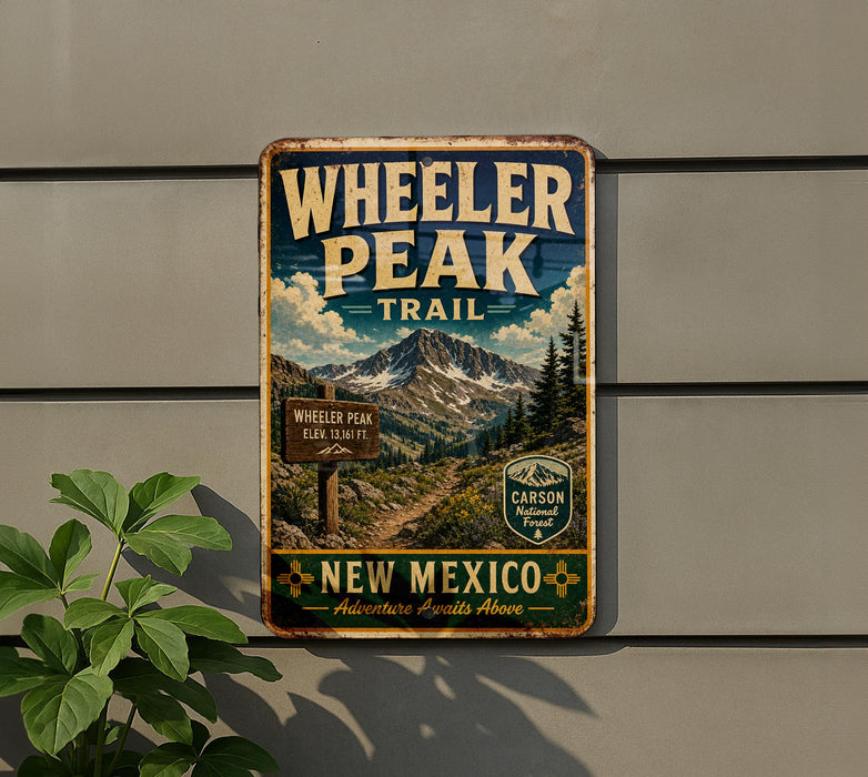 A vintage-style metal sign for Wheeler Peak Trail in New Mexico, featuring a mountain landscape and trail marker.