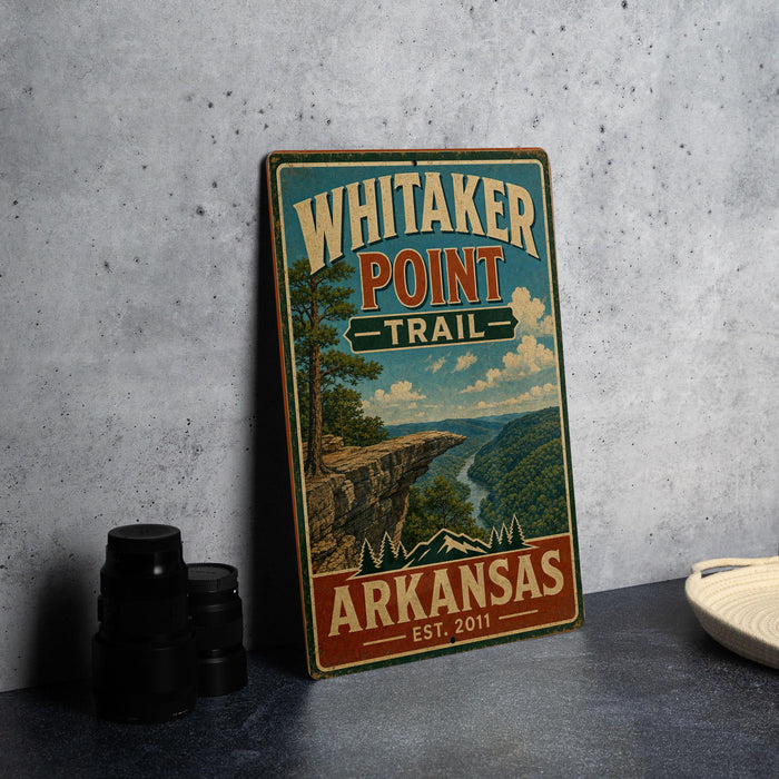 A vintage-style sign for Whitaker Point Trail in Arkansas, featuring a scenic mountain landscape.
