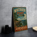 A vintage-style sign for Whitaker Point Trail in Arkansas, featuring a scenic mountain landscape.