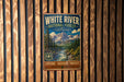 A vintage-style metal sign for the White River National Forest in Colorado, featuring a scenic mountain landscape and a river.