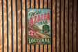 A vintage-style metal sign for the Wild Azalea Trail in Louisiana, featuring a scenic landscape with a road and flowers.