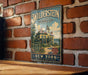 A vintage-style metal sign for the Wilderstein Historic Site in New York, featuring a large illustration of a historic building on the Hudson River.