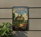 A vintage-style metal sign for Wildstein Historic Site, featuring a large illustration of a house on the Hudson River.