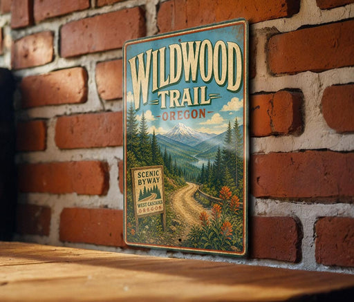 A vintage-style metal sign for the Wildwood Trail in Oregon, featuring a scenic mountain landscape and a winding road.