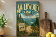 a vintage-style metal sign with a scenic mountain landscape, surrounded by a wooden cutting board and a potted plant.