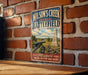 A vintage-style metal sign for Wilson's Creek National Battlefield in Missouri, featuring a cannon and a monument in a rural setting.