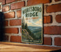 A vintage-style metal sign for Wurtsboro Ridge State Forest in New York, featuring a scenic mountain landscape with pine trees and a river.
