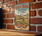 A vintage metal sign with the text "Würzburg Residence with the Court Gardens of Residence Square" and "GERMANY" printed on it, hanging on a brick wall.