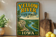 A vintage-style sign for the Yellow River State Forest in Iowa, featuring a scenic illustration of a river and mountains.