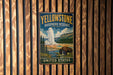 A vintage-style metal sign for Yellowstone Biosphere Reserve in the United States, featuring a bison and a geyser in a scenic landscape.