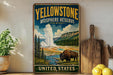 A vintage-style sign for Yellowstone Biosphere Reserve, featuring a bison in a scenic landscape with a geyser and mountains in the background.
