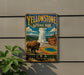 A vintage-style metal sign for Yellowstone National Park, featuring an illustration of a bison and a geyser, mounted on a wall.