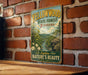 A vintage-style sign for the Yellowwood State Forest in Indiana, featuring a scenic landscape with a river and mountains.