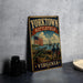 A vintage metal sign with the text "YORKTOWN BATTLEFIELD VIRGINIA" and an illustration of a cannon, soldiers, and a ship, all set against a backdrop of a flag and a body of water.