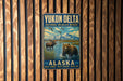 A vintage metal sign for Yukon Delta National Wildlife Refuge in Alaska, featuring a moose and a bear in a natural setting.