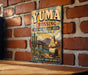 A vintage-style metal sign for Yuma Crossing, a National Heritage Area in Arizona, featuring a desert landscape with a bridge and a wagon.