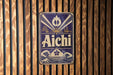 A decorative sign with the word "Aichi" displayed prominently in the center, surrounded by various Japanese-style illustrations and designs.