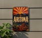A vintage-style sign with the word "ARIZONA" prominently displayed, featuring a desert landscape with mountains, cacti, and a sunburst design.