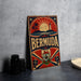 A vintage metal sign with the word "Bermuda" prominently displayed, featuring a sun, palm trees, and a lighthouse, all set against a red and blue background.