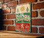 a vintage-style sign with the word "Bulgaria" prominently displayed, mounted on a brick wall.