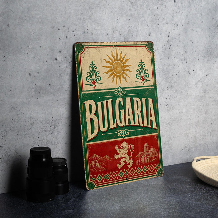 A vintage-style sign for Bulgaria, featuring a sun and floral design, is displayed on a table next to some black camera lenses.
