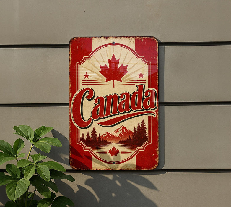 A vintage-style metal sign with the word "Canada" prominently displayed, featuring a maple leaf and a scenic mountain landscape.