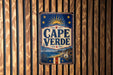 A vintage metal sign with the text "CAPE VERDE" displayed prominently in the center, surrounded by a sun and star motif.