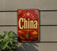 A vintage-style sign with the word "China" prominently displayed, featuring a traditional Chinese temple and landscape in the background.