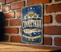 A vintage-style metal sign with the word "Connecticut" prominently displayed, mounted on a brick wall.